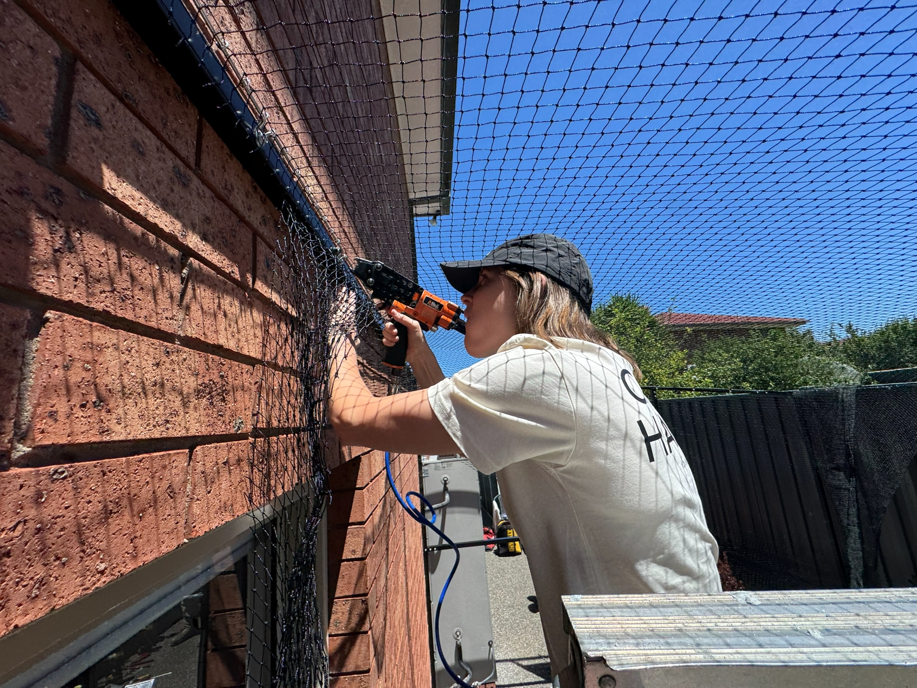 Woman working on outdoor cat enclosure